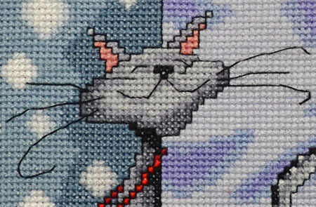 Close up of the detail in a counted thread embroidery of a cat