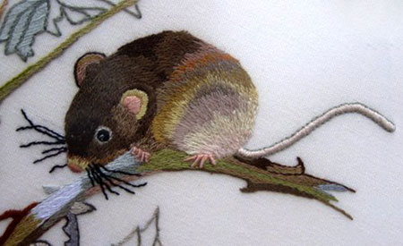 Close up of the detail in a surface embroidery of a mouse